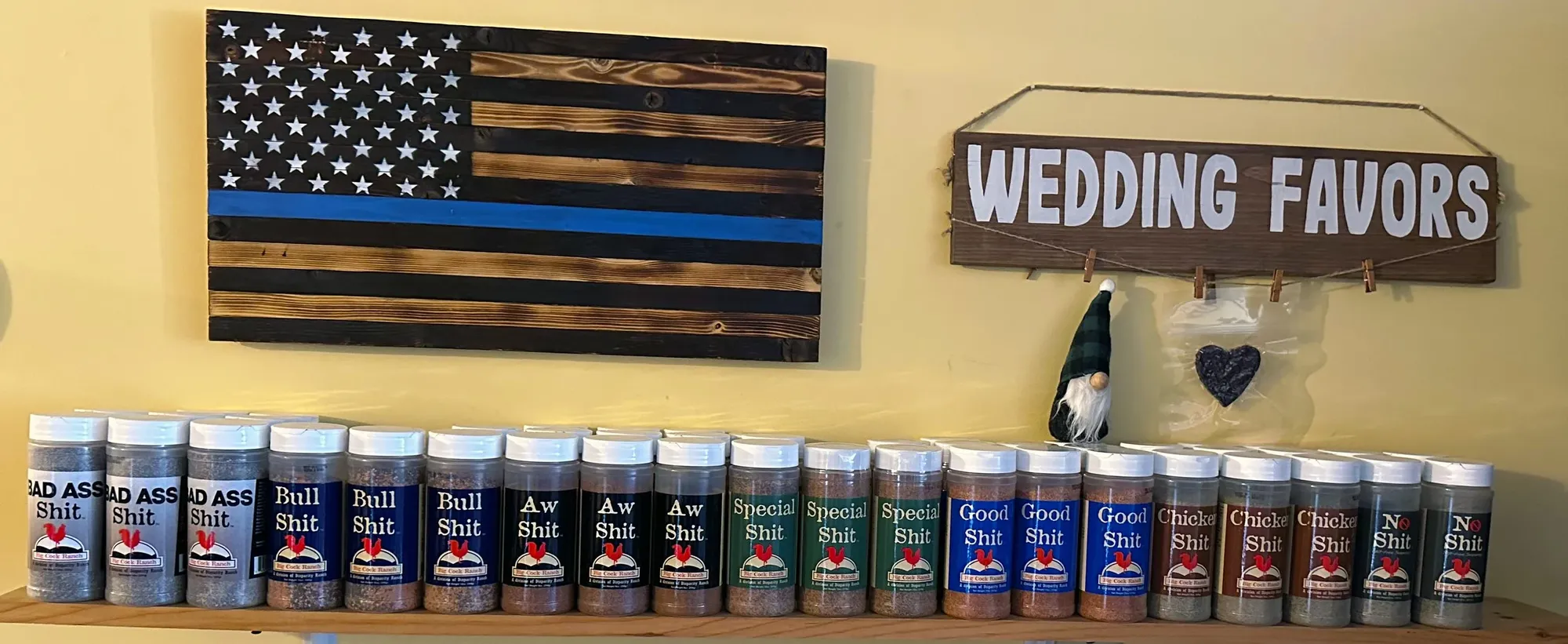 Special Shit seasoning jars lined up on a shelf in the shop, under a wooden American flag and a Wedding Favors sign