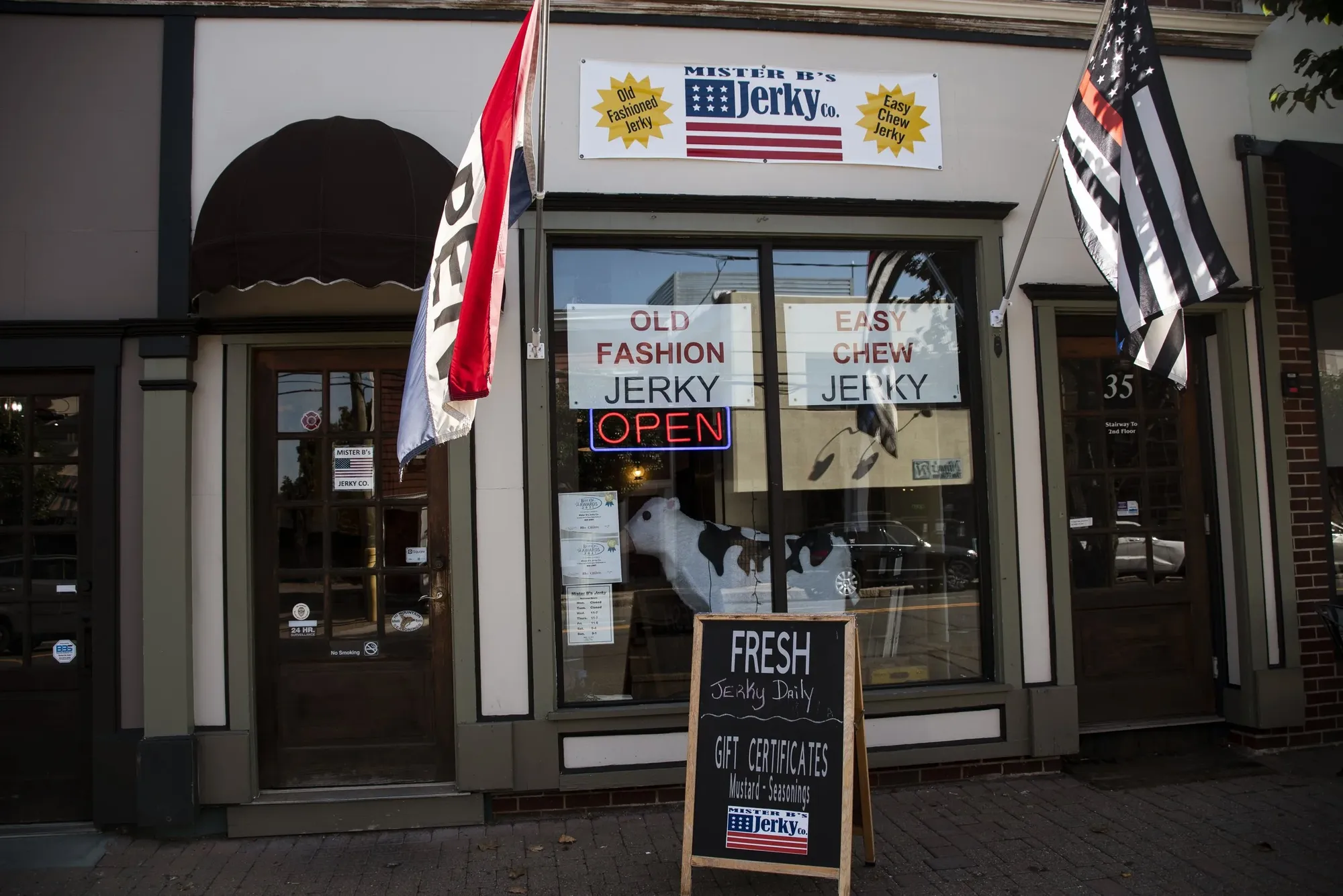 The Mister B’s Jerky Co. storefront on North Main Street, with flags out front, Old Fashion Jerky and Easy Chew Jerky signs in the windows, and a Fresh chalkboard by the door